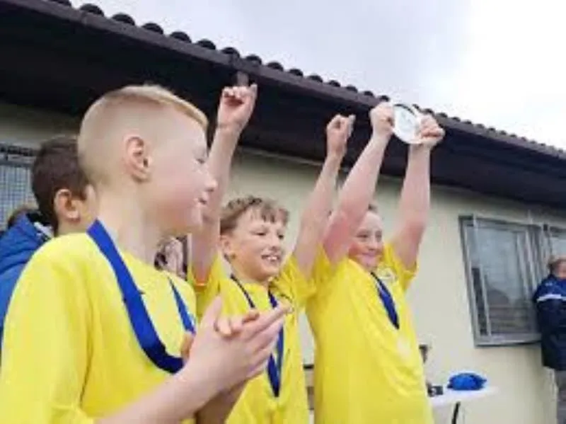 Bootle Bucks players celebrating with medals and raised arms